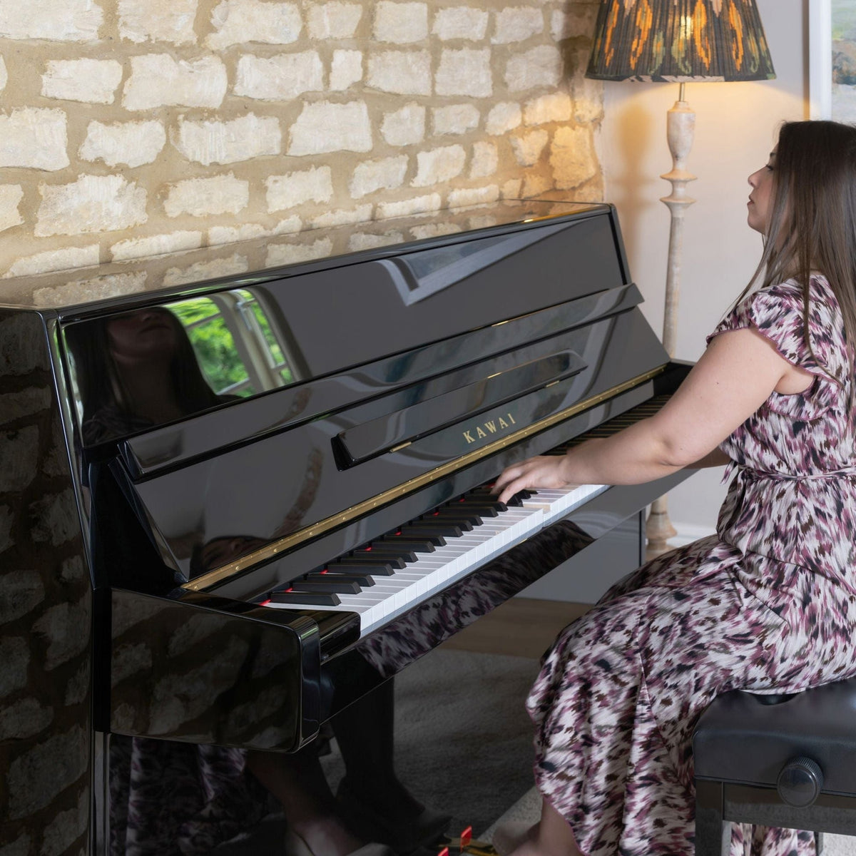 Cô gái đang chơi trên đàn piano KAWAI K15E tại phòng khách