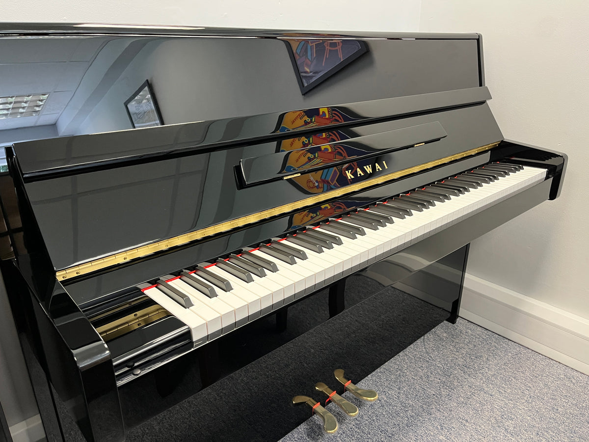 Chụp gần toàn cảnh đàn piano KAWAI K15E, làm lộ rõ màu đen bóng sang trọng, kiểu dáng nhỏ gọn