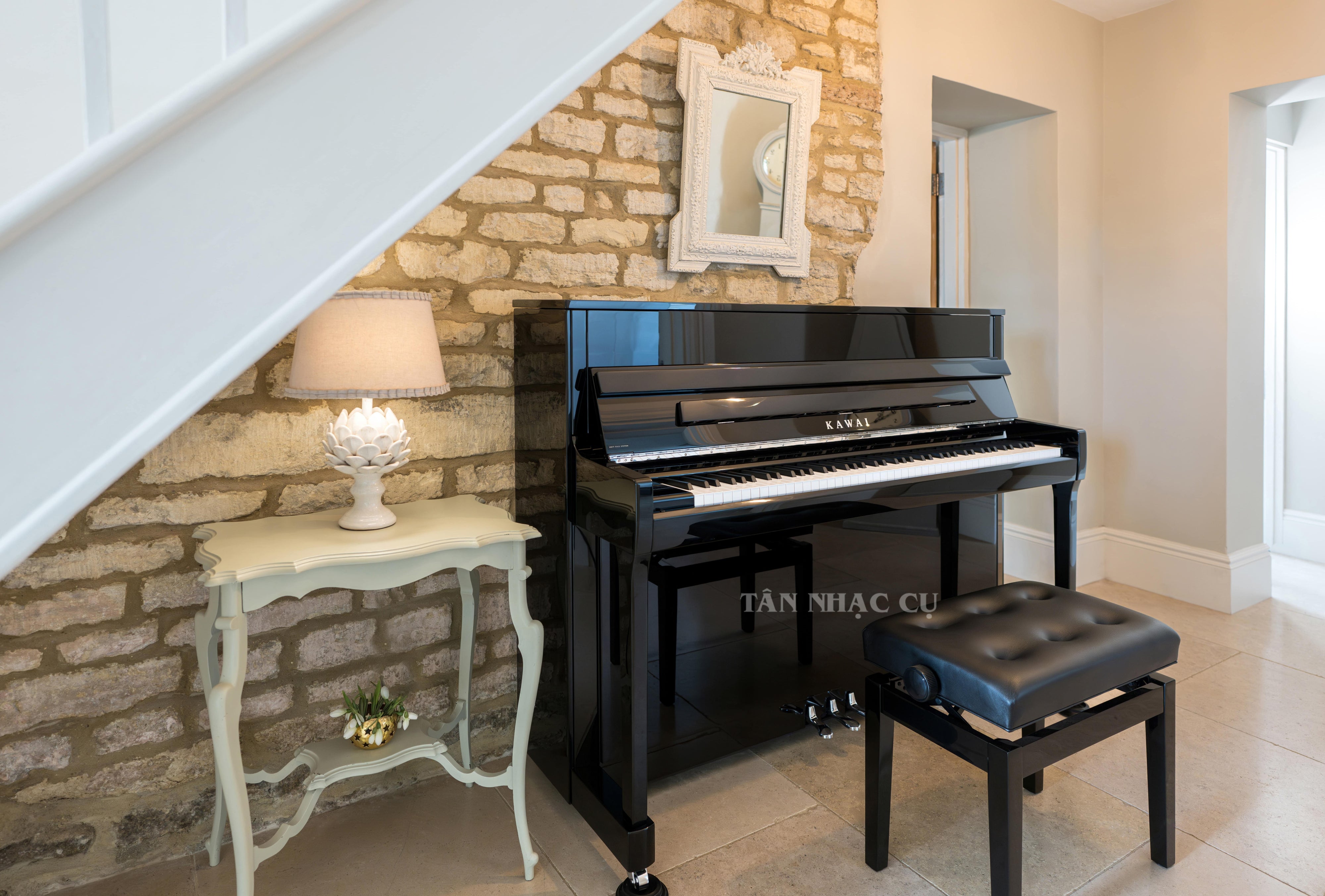 Toàn cảnh đàn piano KAWAI K200 màu đen bóng, đi kèm ghế chính hãng, mở nắp, nghiêng góc trái tại nhà khách hàng của Tân Nhạc Cụ