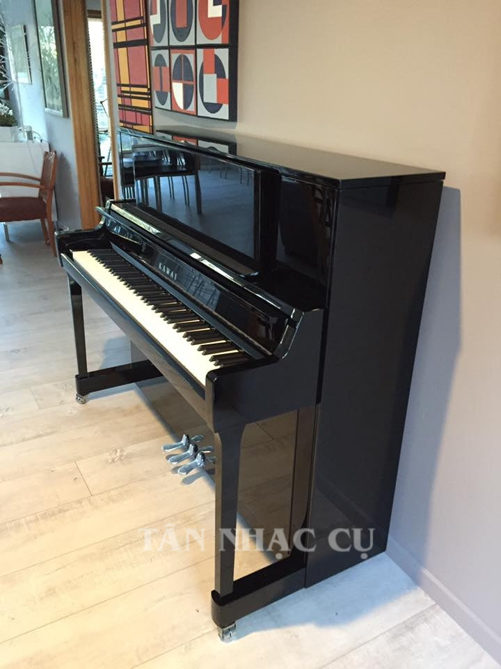 Toàn cảnh đàn piano KAWAI K400 tại nhà khách hàng tiếp theo của Tân Nhạc Cụ, chụp nghiêng bên phải, đàn mới tinh nguyên hộp, sáng bóng, sang trọng trong màu đen bóng polished ebony