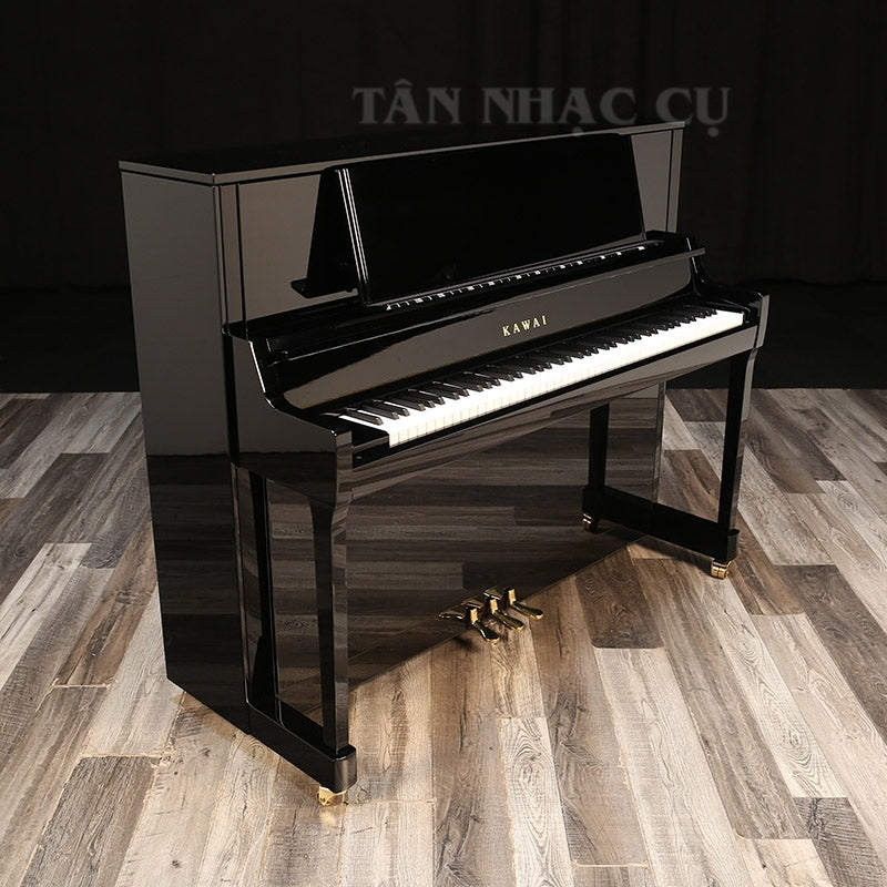 Toàn cảnh đàn piano KAWAI K400,nghiêng bên trái, mở nắp, màu đen bóng sang trọng, kèm ghế tại showroom Tân Nhạc Cụ
