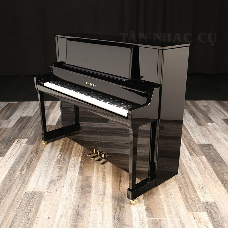 Toàn cảnh đàn piano KAWAI K400, nghiêng bên phải, mở nắp, màu đen bóng sang trọng, kèm ghế tại showroom Tân Nhạc Cụ