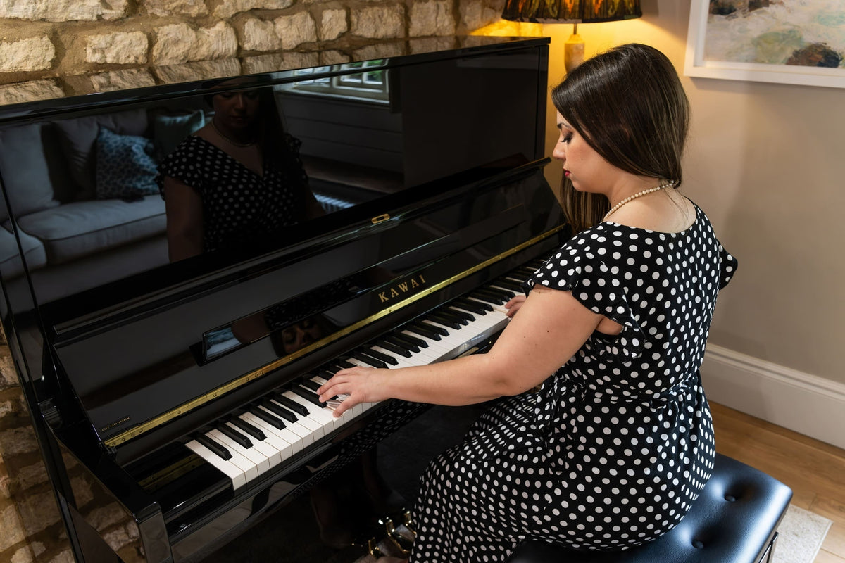 Hình ảnh cô gái đang chơi trên đàn piano KAWAI K600