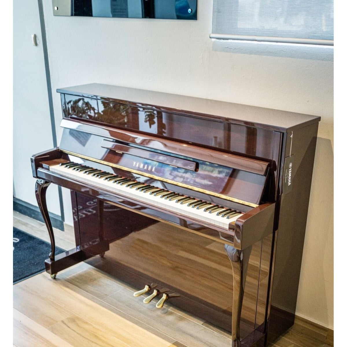 Toàn cảnh đàn piano Yamaha JX113CP màu gỗ gụ bóng, chân cong, sang trọng tại nhà khách hàng của Tân Nhạc Cụ