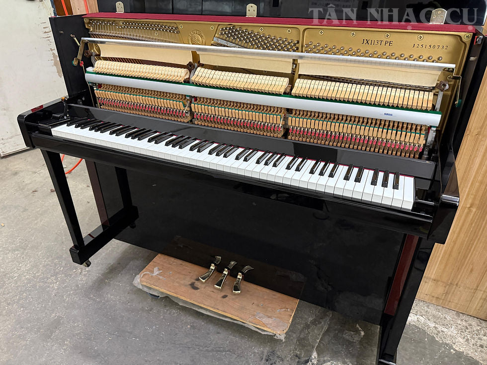 Hình chụp toàn cảnh Đàn piano YAMAHA JX113T màu đen bóng polished ebony với lắp đàn phía trước mở, nhìn rõ bộ máy của đàn tại kho hàng của Tân Nhạc Cụ