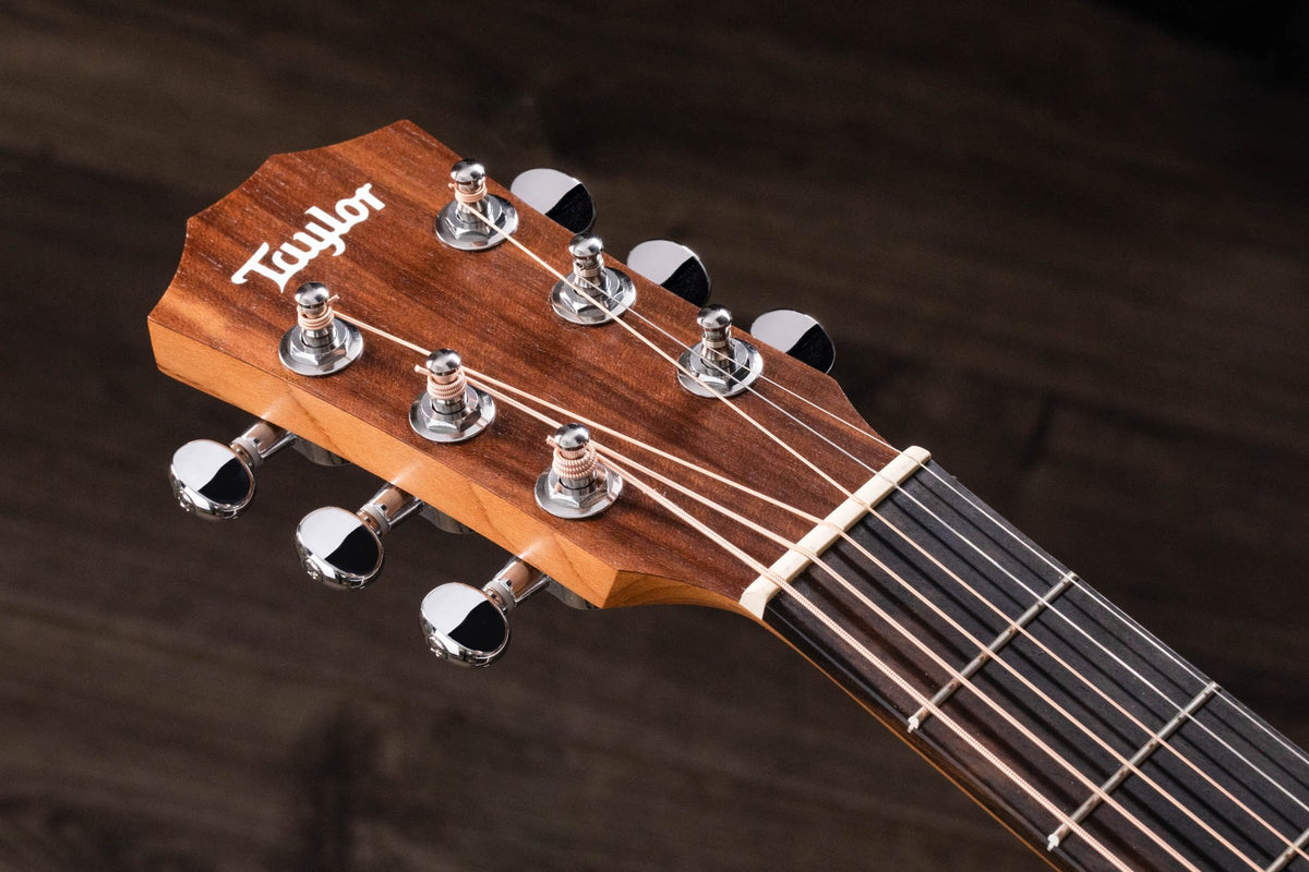 Đàn guitar acoustic điện Baby Taylor BTe Koa màu Natural – cận đầu đàn và logo Taylor