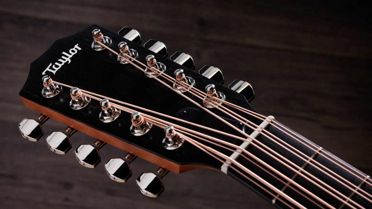 Đàn guitar acoustic điện Taylor 150ce Bajo Quinto màu Natural – cận đầu đàn và logo Taylor