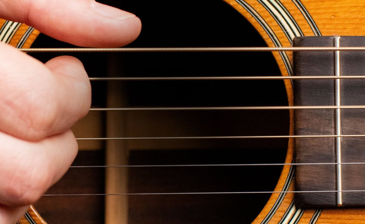 Cận cảnh dây đàn guitar acoustic trên thân đàn