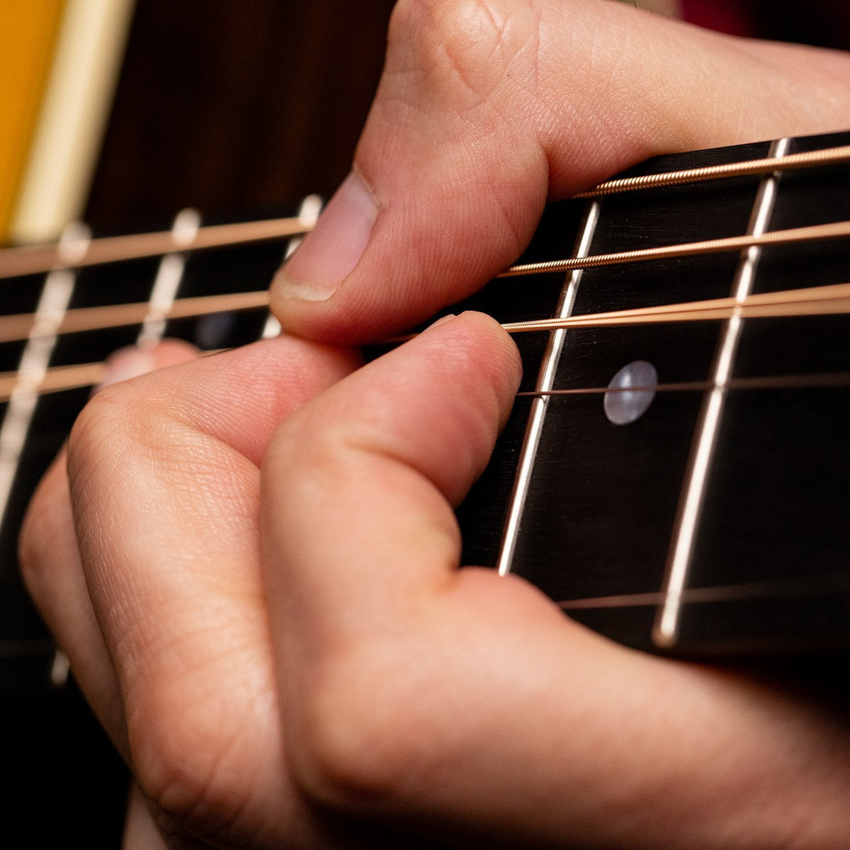 Bấm hợp âm trên dây đàn guitar acoustic