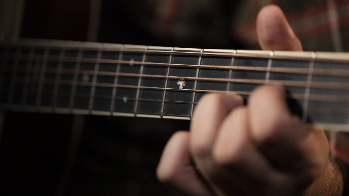Bấm phím trên đàn guitar acoustic