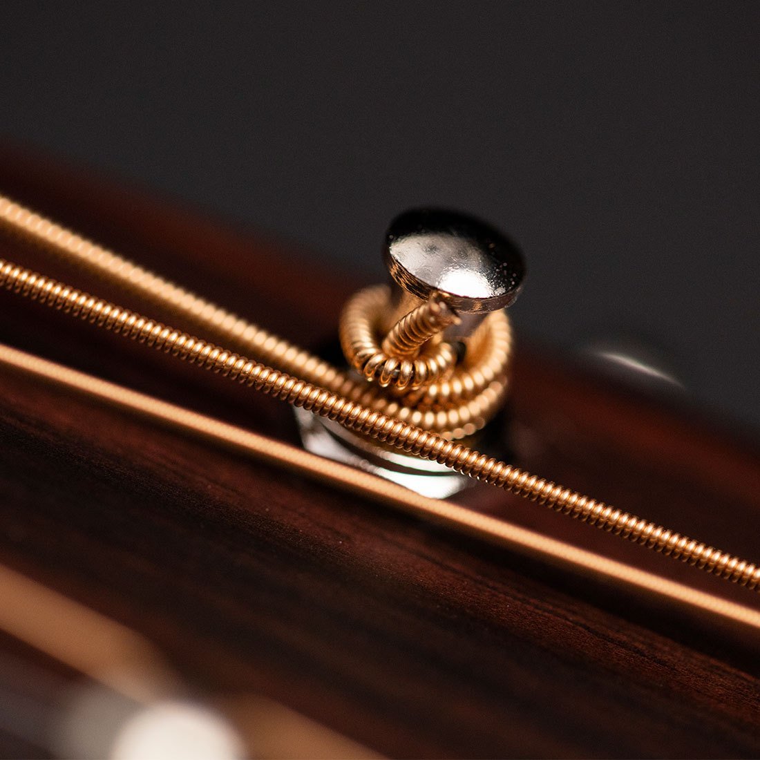 Dây đàn guitar acoustic quấn trên trục lên dây