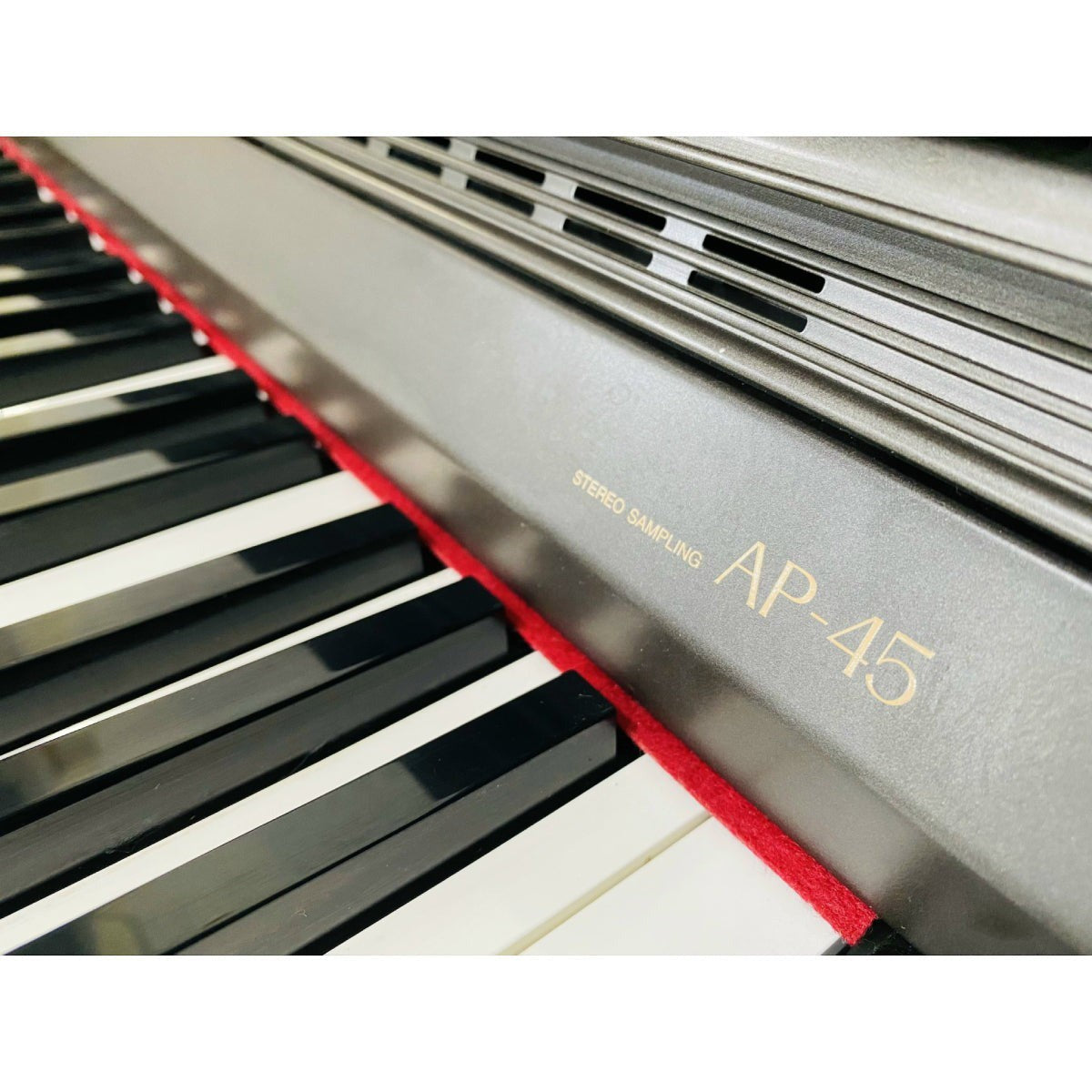 Cận cảnh bàn phím và logo Casio AP45 tại TÂN NHẠC CỤ, đàn piano điện dáng tủ với công nghệ Stereo Sampling
