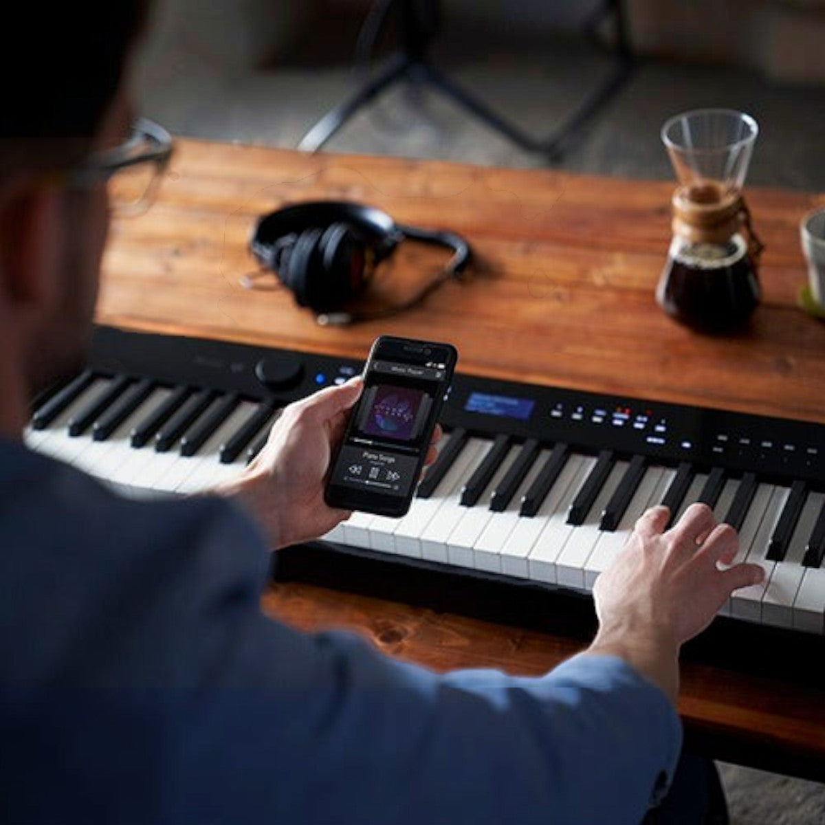 Người chơi sử dụng điện thoại kết nối Bluetooth với đàn piano điện TÂN NHẠC CỤ Casio PX-S1000 mỏng hiện đại
