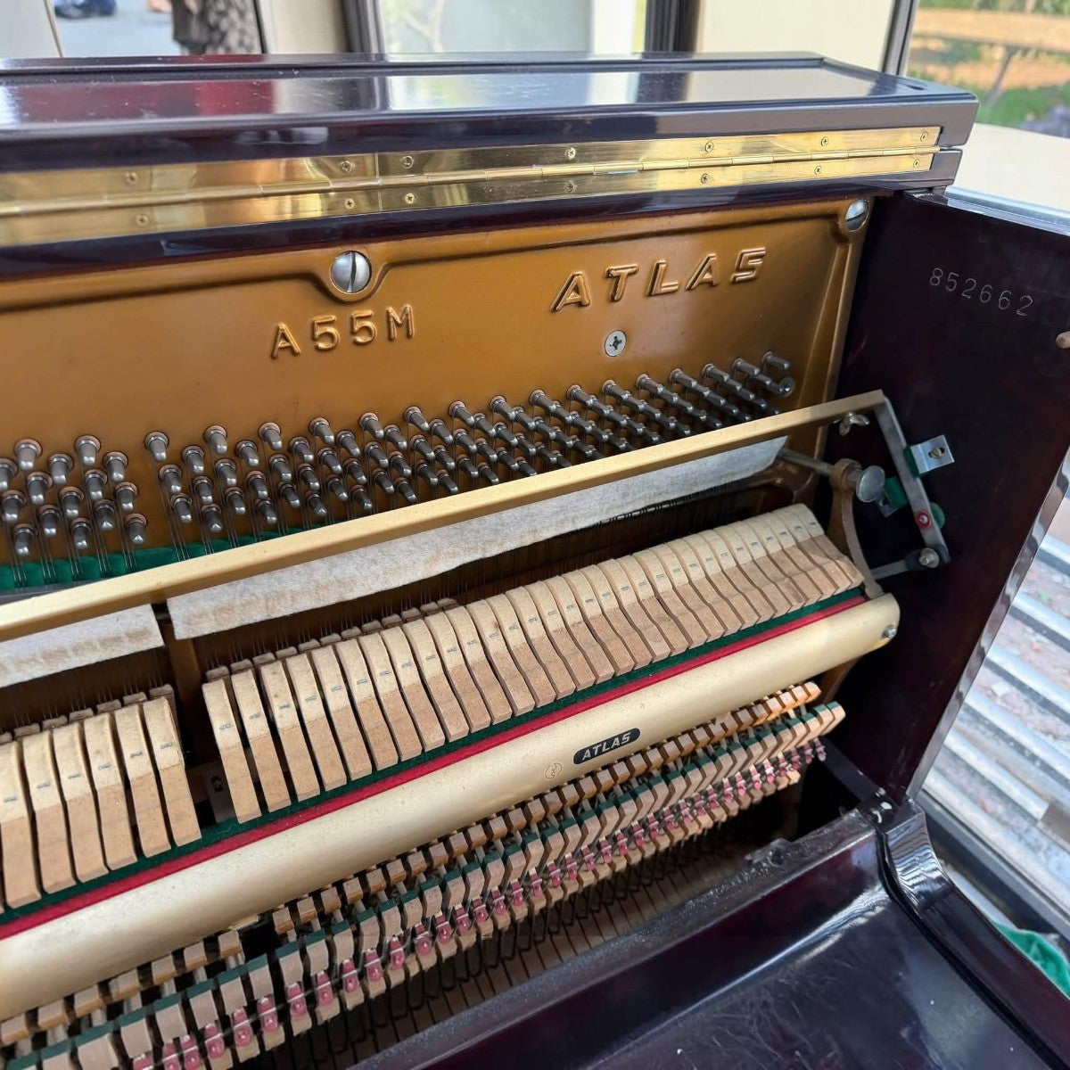 Bên trong đàn piano cơ Atlas A55M tại TÂN NHẠC CỤ với khung gang, búa đàn và số serial rõ nét