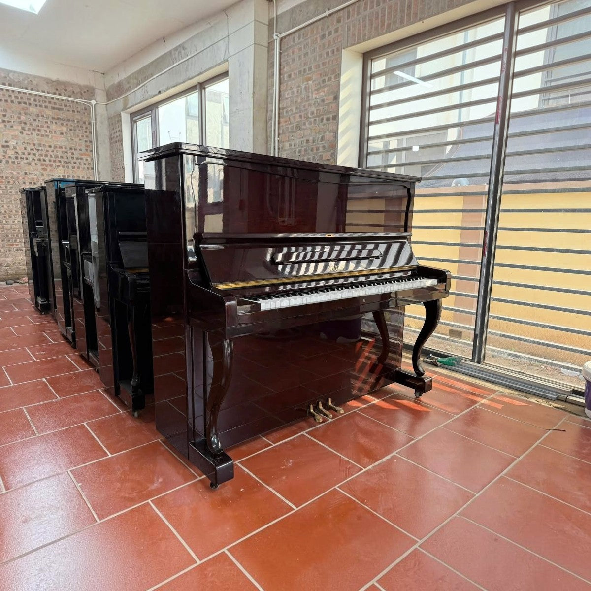 Đàn piano cơ upright Atlas A55M màu đỏ rượu vang bóng sang trọng tại cửa hàng TÂN NHẠC CỤ