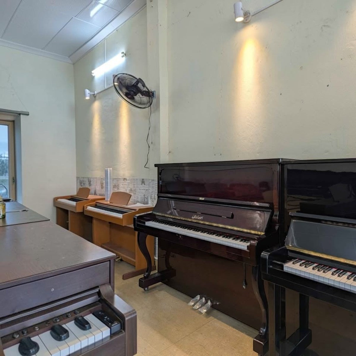 Đàn piano cơ Atlas A55M màu đỏ rượu vang bóng tại cửa hàng TÂN NHẠC CỤ, thiết kế upright sang trọng và bền bỉ.