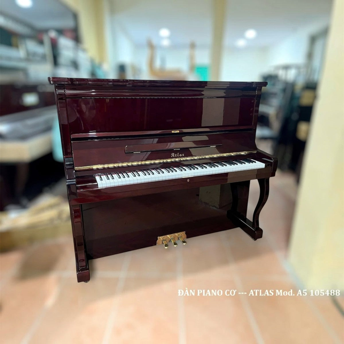 Đàn piano cơ upright TÂN NHẠC CỤ Atlas A5V màu đỏ rượu vang bóng sang trọng với thiết kế cổ điển và 3 pedal đồng