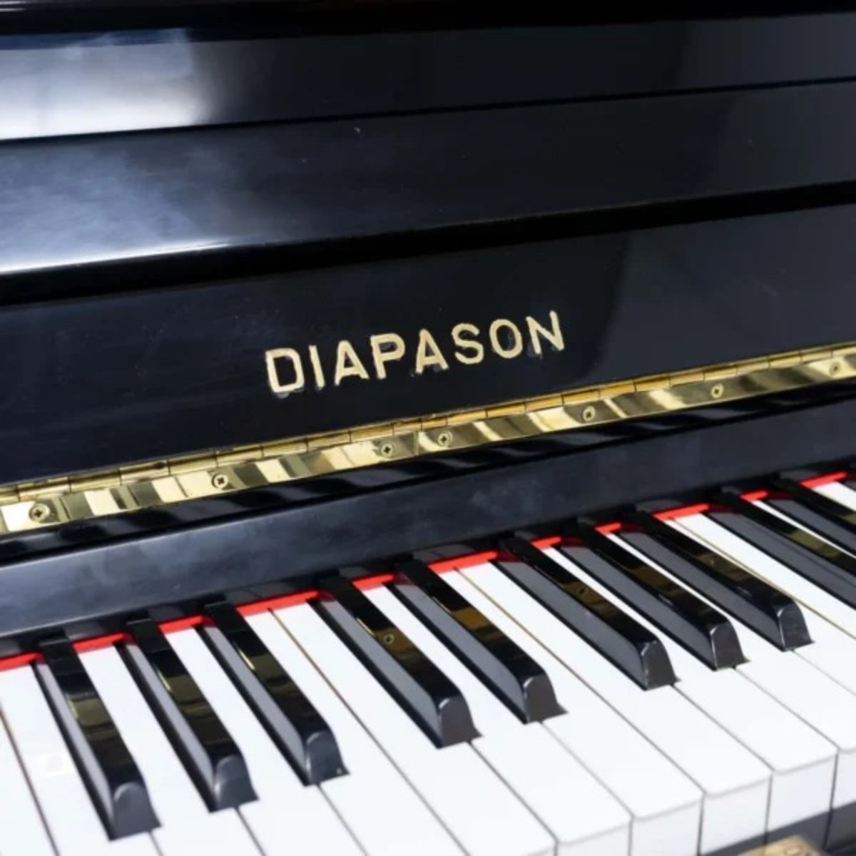 Đàn piano cơ upright TÂN NHẠC CỤ Diapason 125M1 màu đen bóng với logo thương hiệu nổi bật trên nắp phím