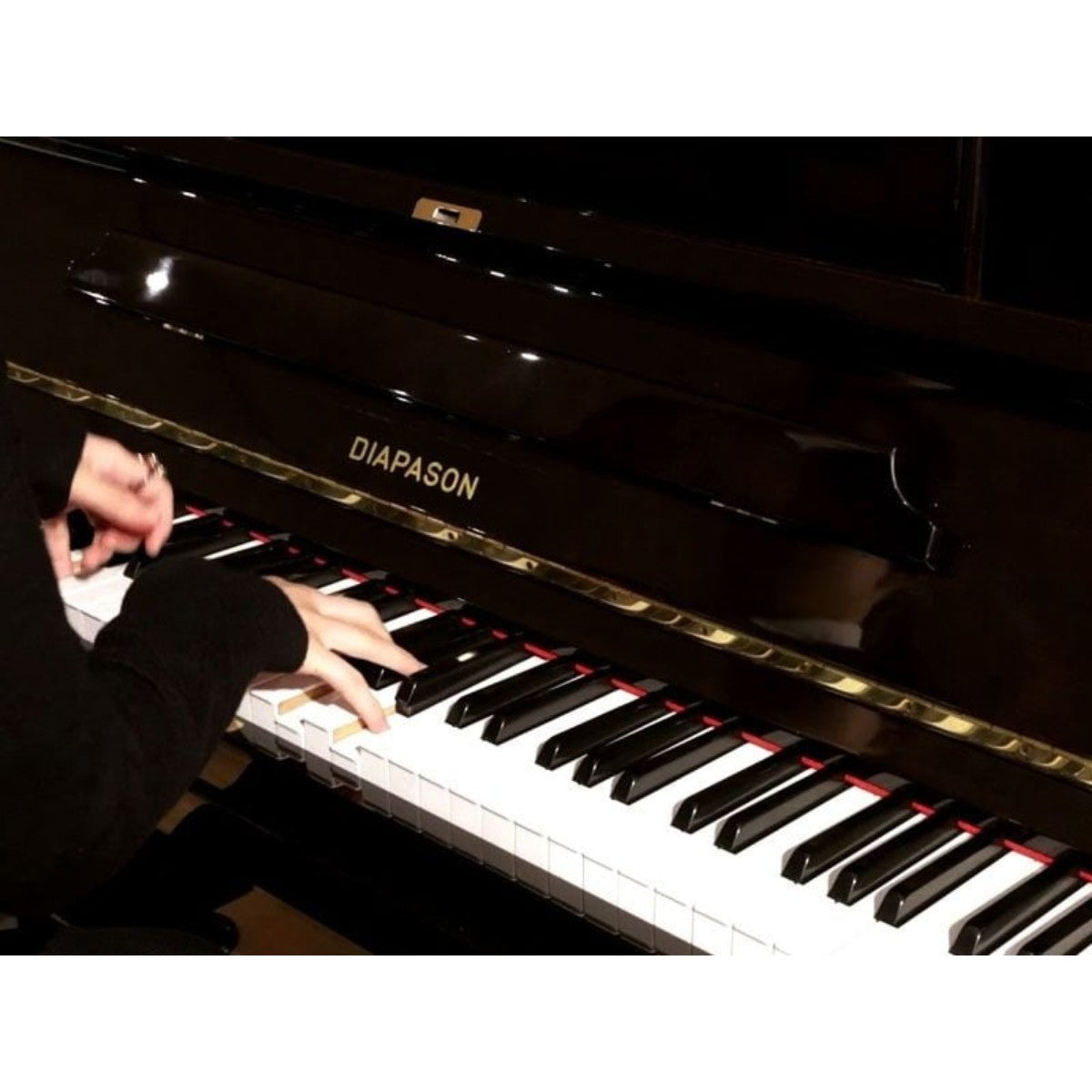 Đàn piano cơ TÂN NHẠC CỤ Diapason D66W màu đen bóng sang trọng với bàn phím 88 nốt đang được nghệ sĩ chơi