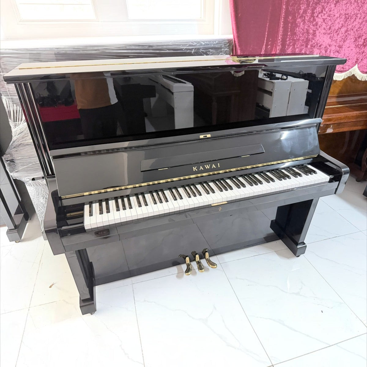 Đàn piano cơ upright Kawai BL51 màu đen bóng sang trọng tại Tân Nhạc Cụ với thiết kế cổ điển và bàn phím 88 phím.