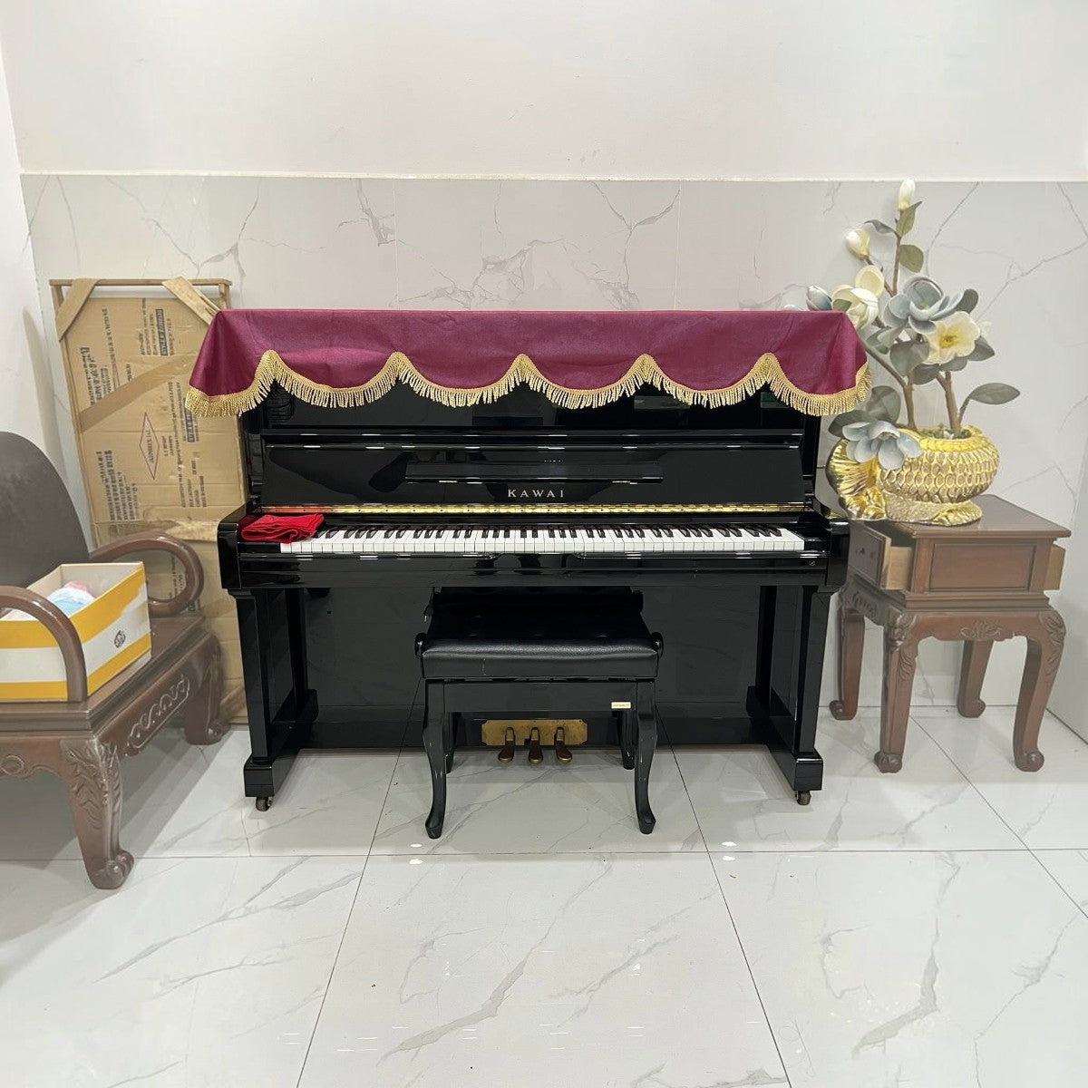 Đàn piano cơ upright Kawai BS2A màu đen bóng tại cửa hàng TÂN NHẠC CỤ, thiết kế sang trọng với khăn phủ đàn đỏ.
