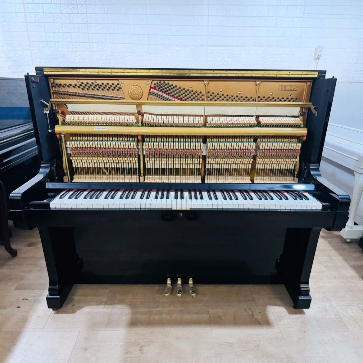 Đàn piano cơ upright Kawai KS5F màu đen bóng với nắp trên mở lộ bộ máy bên trong tại cửa hàng TÂN NHẠC CỤ
