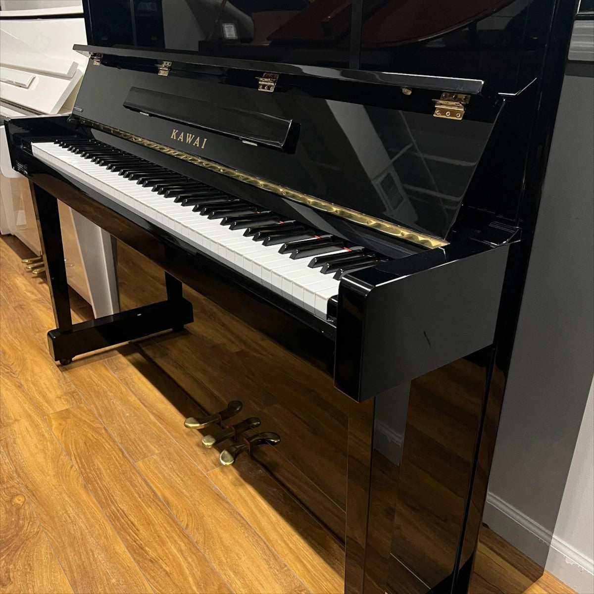 Đàn piano cơ upright Kawai KU10 màu đen bóng sang trọng tại TÂN NHẠC CỤ, thiết kế cổ điển với 3 pedal đồng