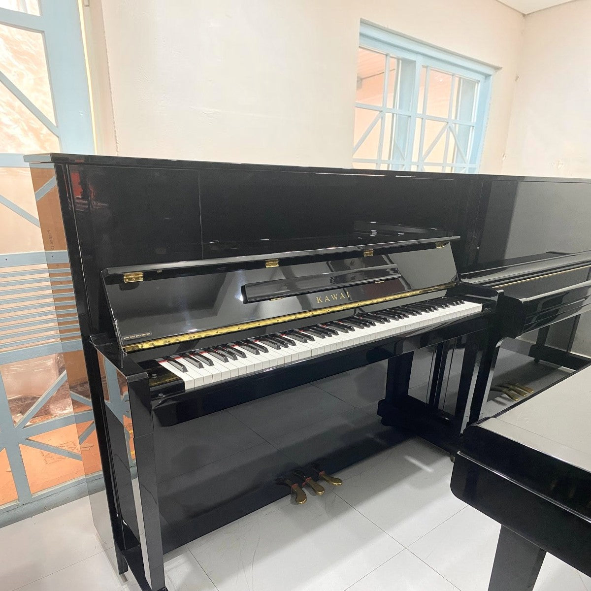 Đàn piano cơ upright Kawai KU10 màu đen bóng sang trọng tại TÂN NHẠC CỤ, thiết kế cổ điển, bền bỉ cho người mới học.