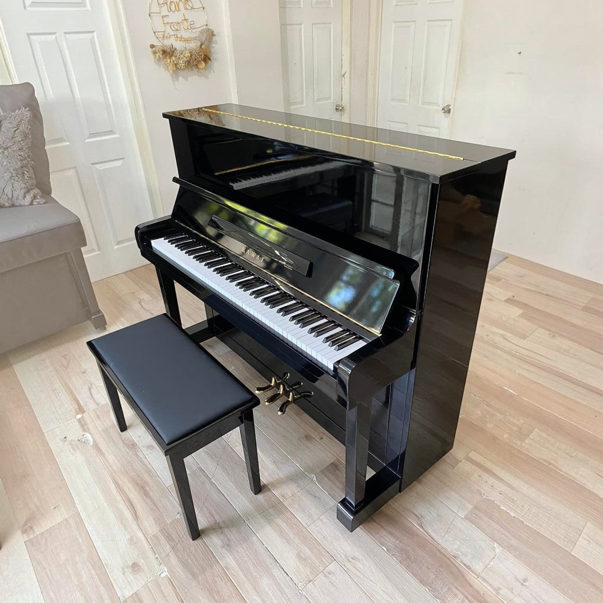 Đàn piano cơ Kawai KU1D màu đen bóng sang trọng tại TÂN NHẠC CỤ, thiết kế upright cổ điển với ghế đàn đi kèm.