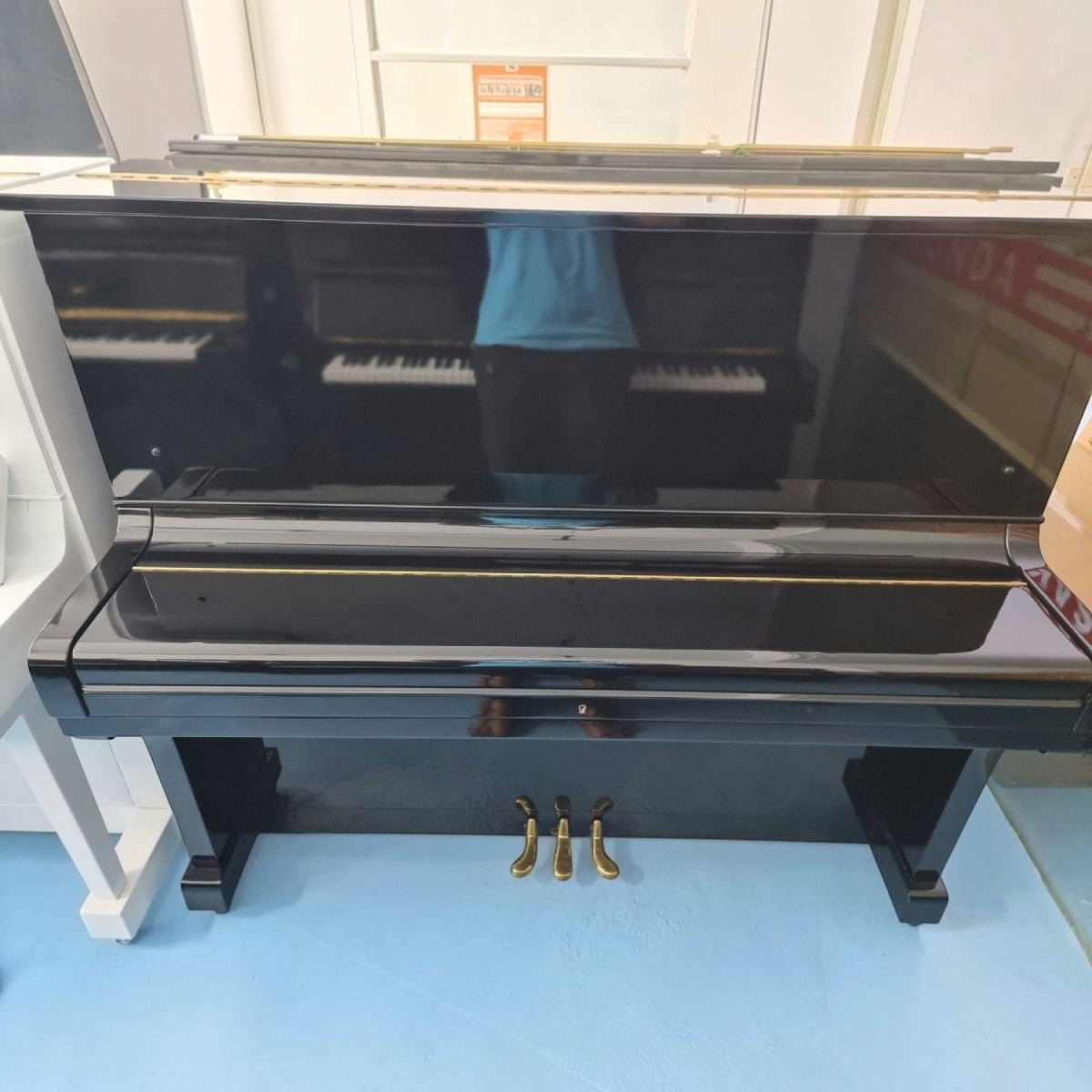 Đàn piano cơ upright Kawai KU3 màu đen bóng sang trọng tại Tân Nhạc Cụ với thiết kế cổ điển và 3 pedal vàng