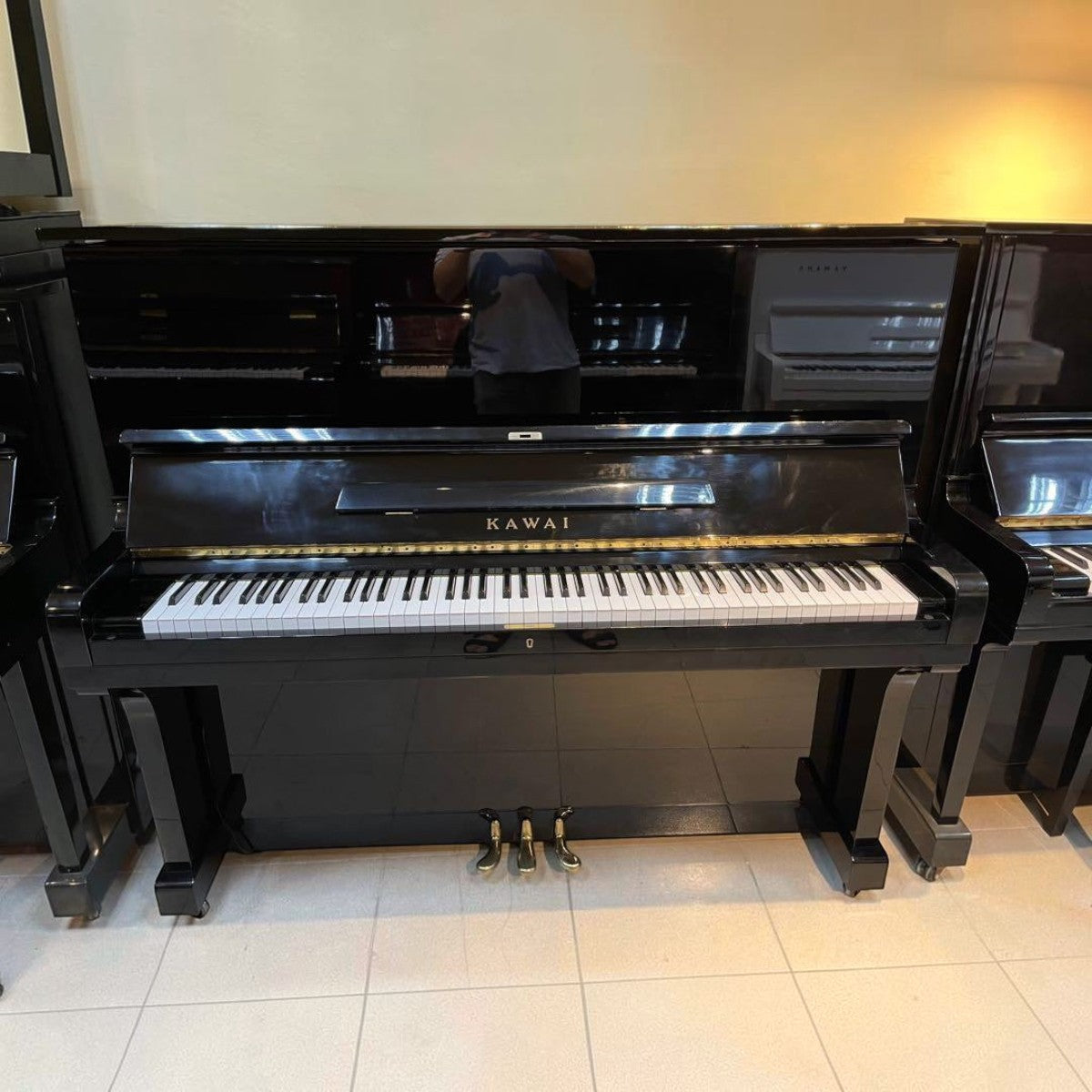 Đàn piano cơ upright Kawai KU3 màu đen bóng sang trọng tại TÂN NHẠC CỤ, thiết kế cổ điển với 3 pedal chắc chắn.