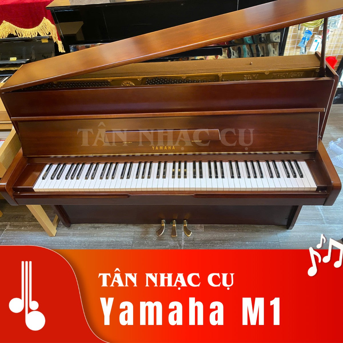 Đàn piano cơ Yamaha M1 màu gỗ nâu tại Tân Nhạc Cụ, thiết kế upright nhỏ gọn với nắp đàn mở lộ khung gang bên trong