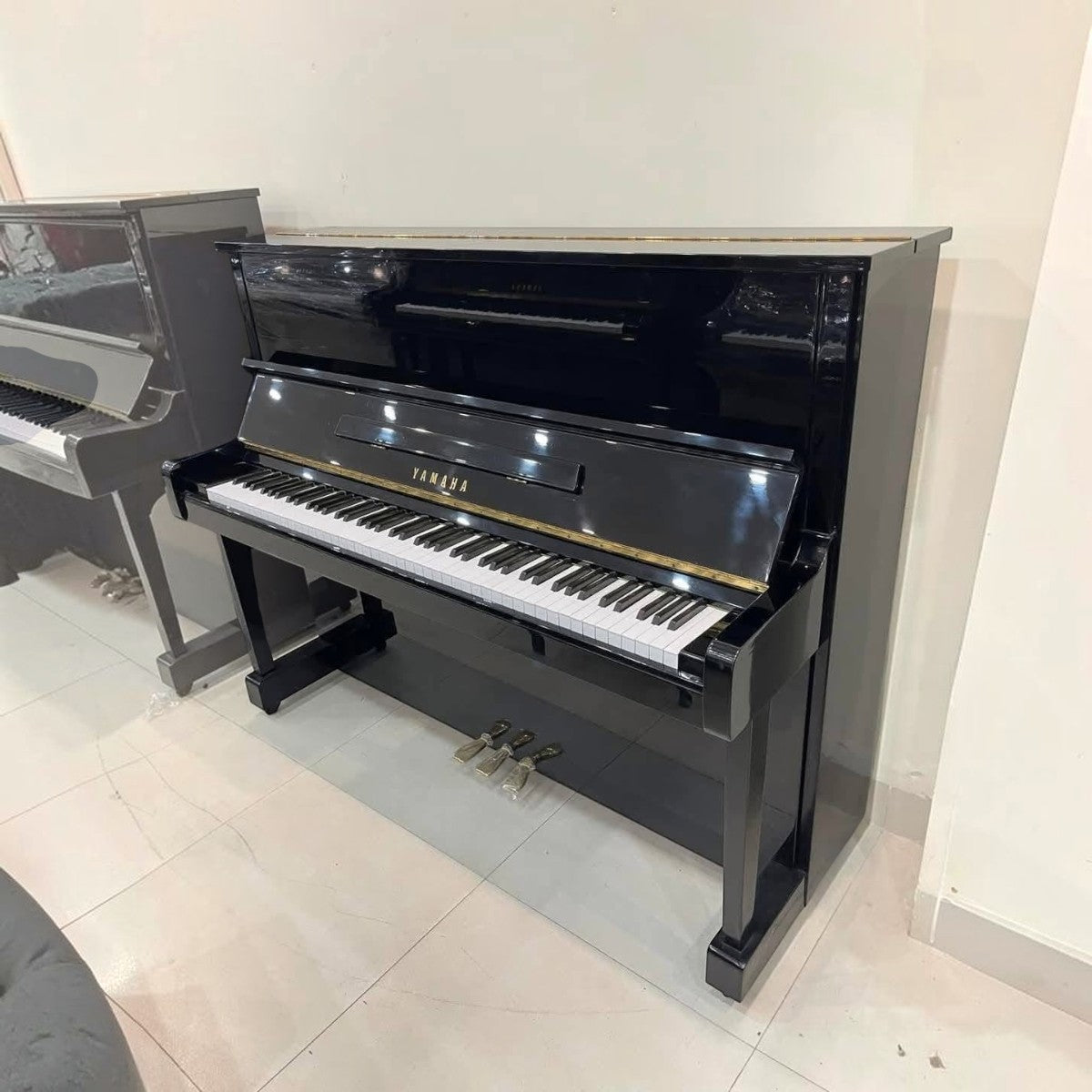 Đàn piano cơ Yamaha MC301 màu đen bóng sang trọng tại Tân Nhạc Cụ, thiết kế upright nhỏ gọn 121cm bền bỉ.