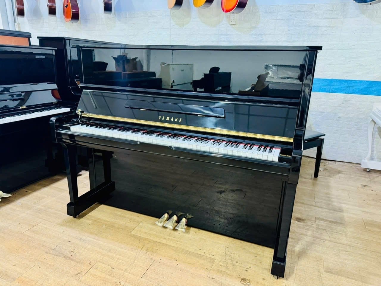 Đàn piano cơ Yamaha U100 màu đen bóng sang trọng tại TÂN NHẠC CỤ, thiết kế upright hiện đại với 3 pedal tiện dụng.