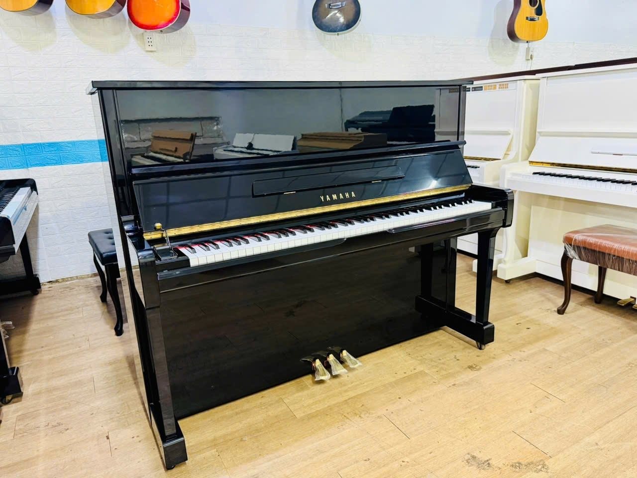 Đàn piano cơ Yamaha U100 màu đen bóng sang trọng tại TÂN NHẠC CỤ, thiết kế upright hiện đại với 3 pedal