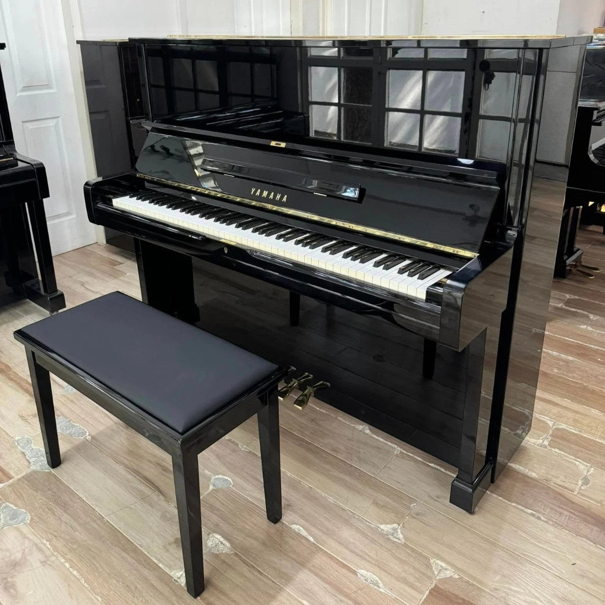 Đàn piano cơ Yamaha U2A màu đen bóng sang trọng tại TÂN NHẠC CỤ, thiết kế upright cổ điển với ghế đàn đi kèm.