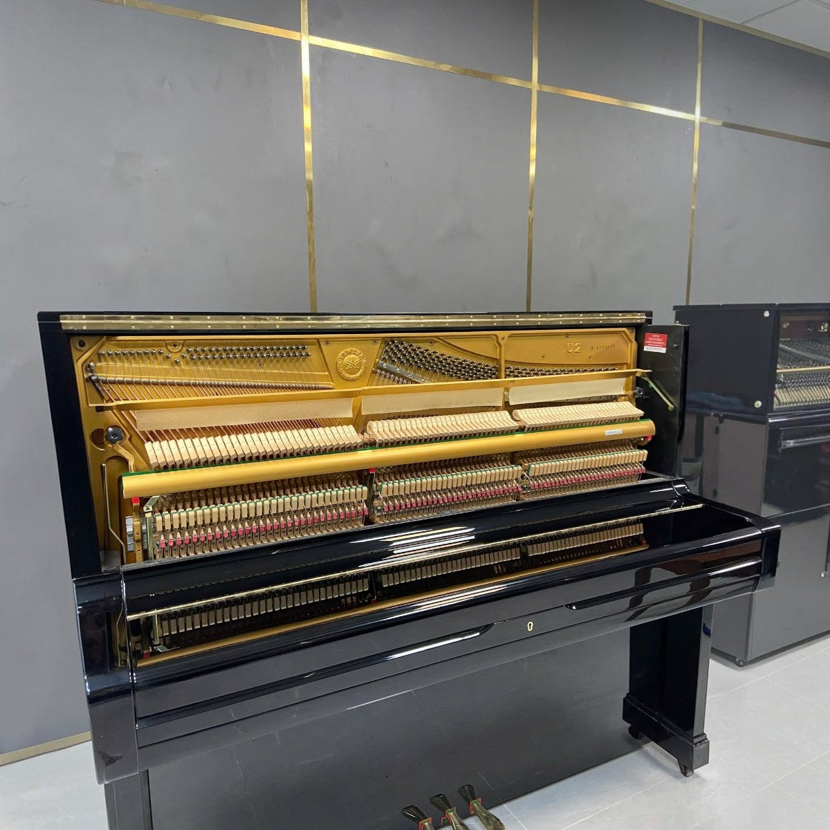 Đàn piano cơ Yamaha U2A màu đen bóng tại TÂN NHẠC CỤ với bộ máy bên trong lộ rõ, thiết kế sang trọng và tinh tế.