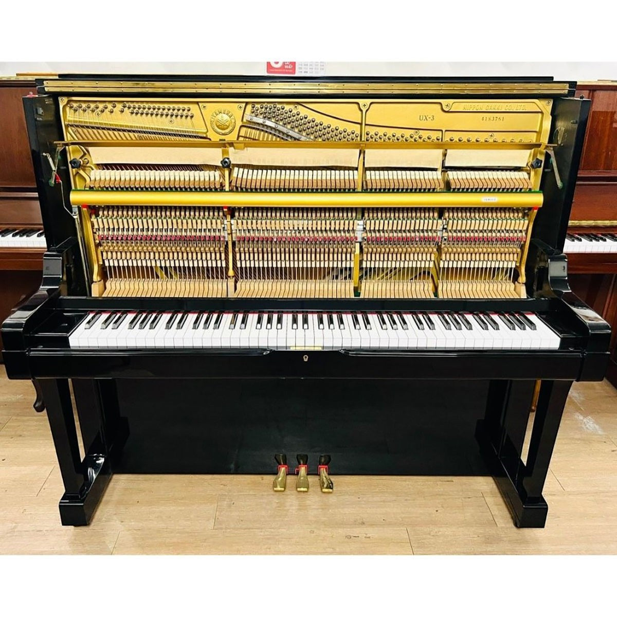 Đàn piano cơ Yamaha UX3 màu đen bóng với khung chữ X cao cấp tại TÂN NHẠC CỤ, nhìn rõ bộ máy bên trong.