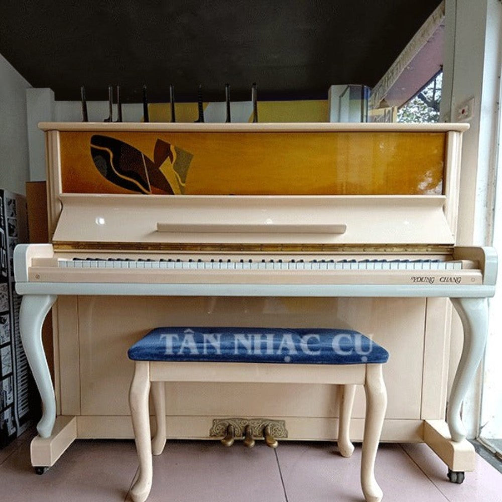 Đàn piano cơ TÂN NHẠC CỤ Young Chang U121 màu kem trang nhã với thiết kế upright cổ điển và ghế ngồi bọc nhung xanh