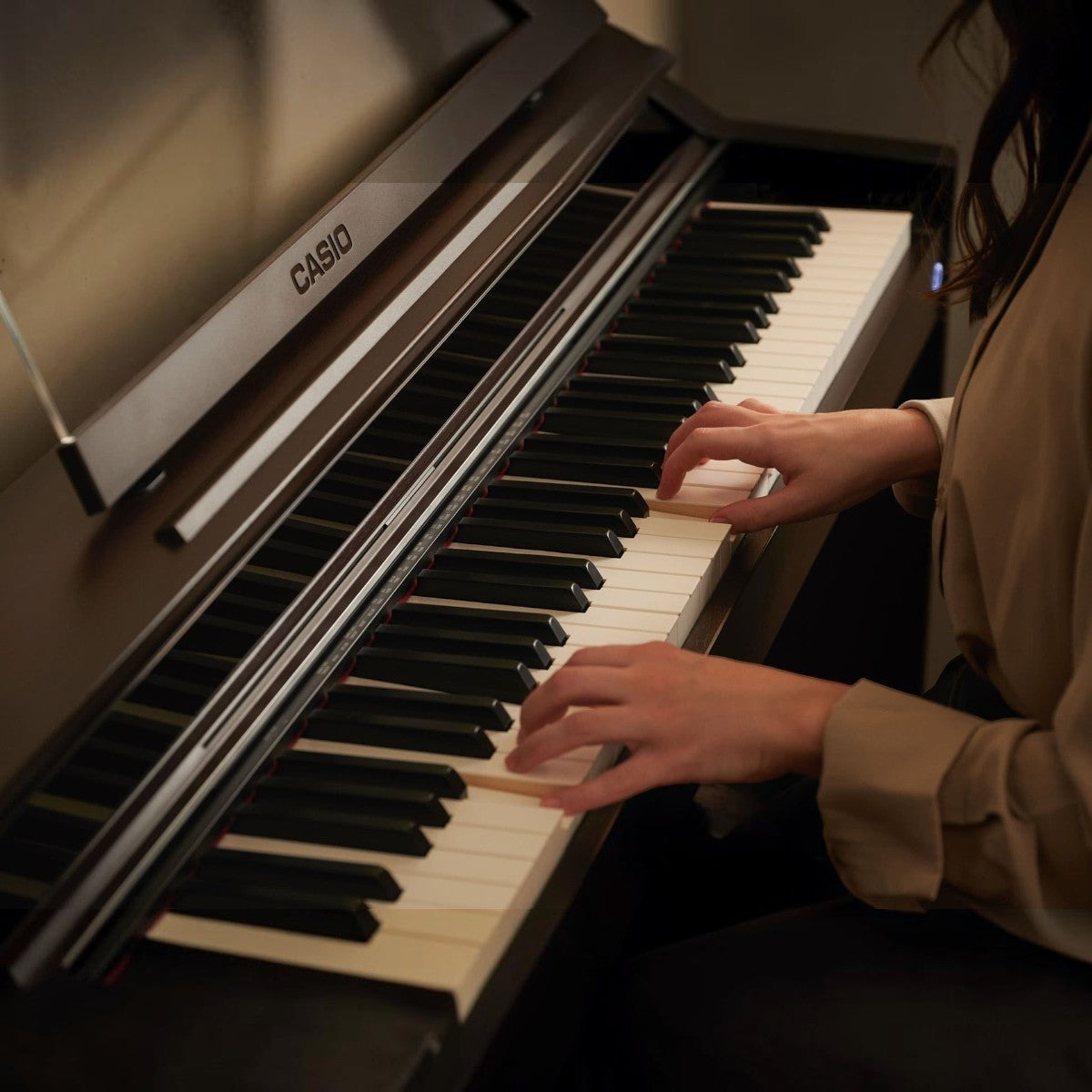 Người chơi đang sử dụng đàn piano điện Casio AP-S450 với bàn phím gỗ-nhựa composite tại showroom TÂN NHẠC CỤ