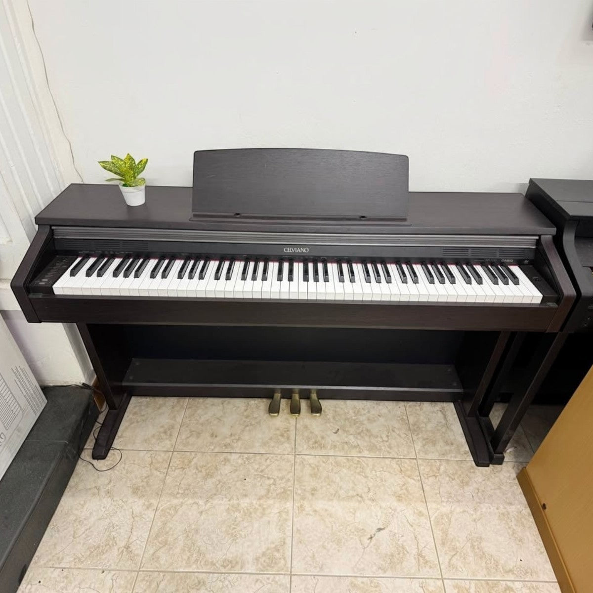 Đàn piano điện Casio AP200 dáng tủ màu nâu đen sang trọng tại TÂN NHẠC CỤ, thiết kế 88 phím búa chắc chắn.
