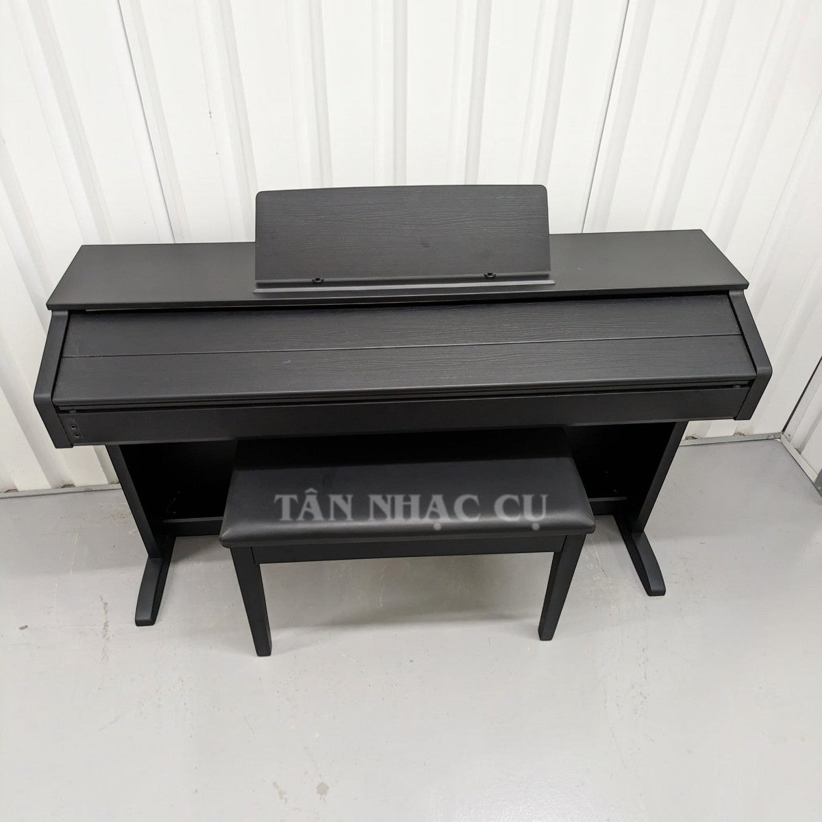 Đàn piano điện Casio AP260 màu đen dáng tủ tại TÂN NHẠC CỤ, thiết kế sang trọng với giá để nhạc và ghế đi kèm.
