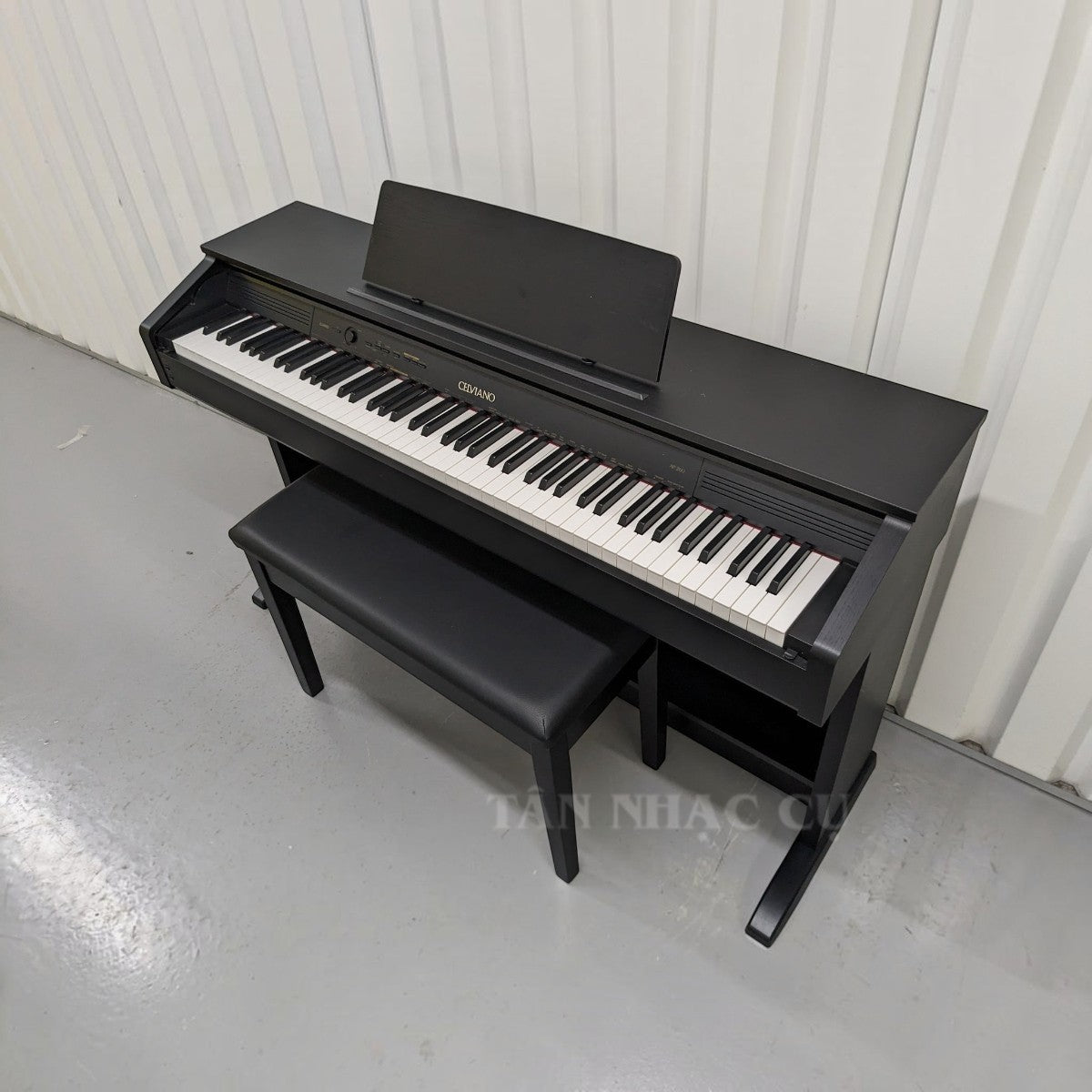 Đàn piano điện Casio AP260 màu đen dáng tủ tại TÂN NHẠC CỤ với bàn phím búa Tri-sensor và ghế đàn đi kèm.