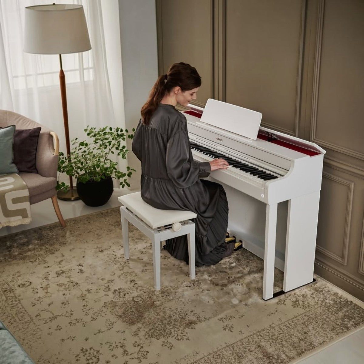 Người phụ nữ đang chơi đàn piano điện Casio AP-300 màu trắng sang trọng tại showroom TÂN NHẠC CỤ