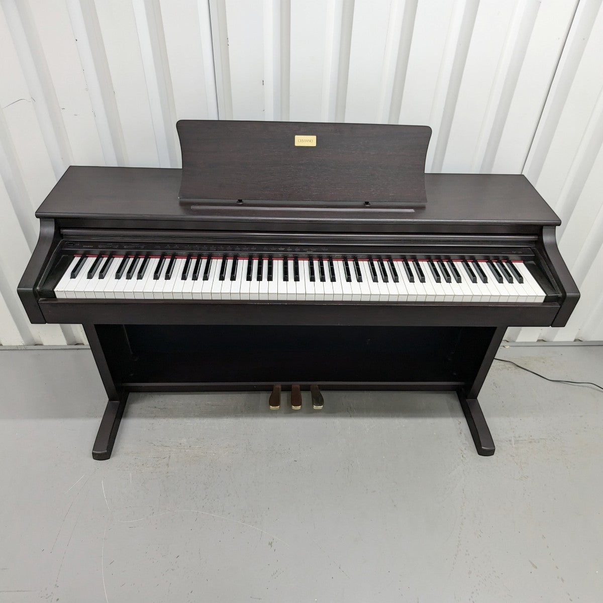 Đàn piano điện TÂN NHẠC CỤ Casio AP-38 màu nâu gỗ sang trọng với thiết kế tủ đứng cổ điển và 3 pedal