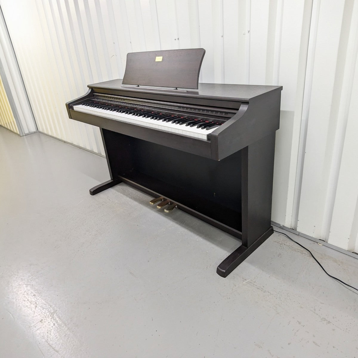 Đàn piano điện Casio AP-38 màu nâu gỗ tại TÂN NHẠC CỤ với thiết kế tủ đứng cổ điển và bàn phím búa 88 phím.