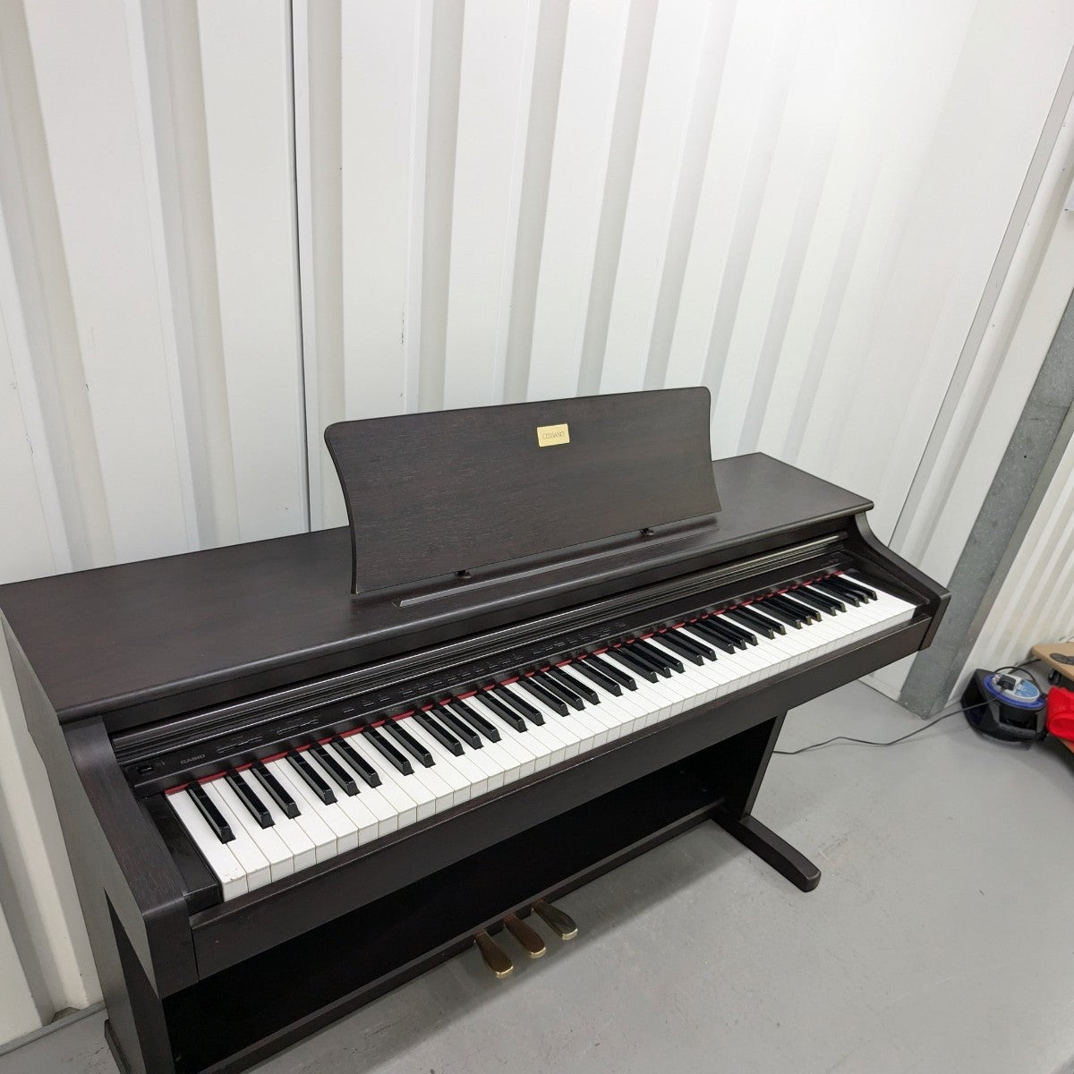 Đàn piano điện Casio AP-38 màu nâu gỗ sang trọng tại Tân Nhạc Cụ, thiết kế tủ đứng cổ điển với 88 phím búa.
