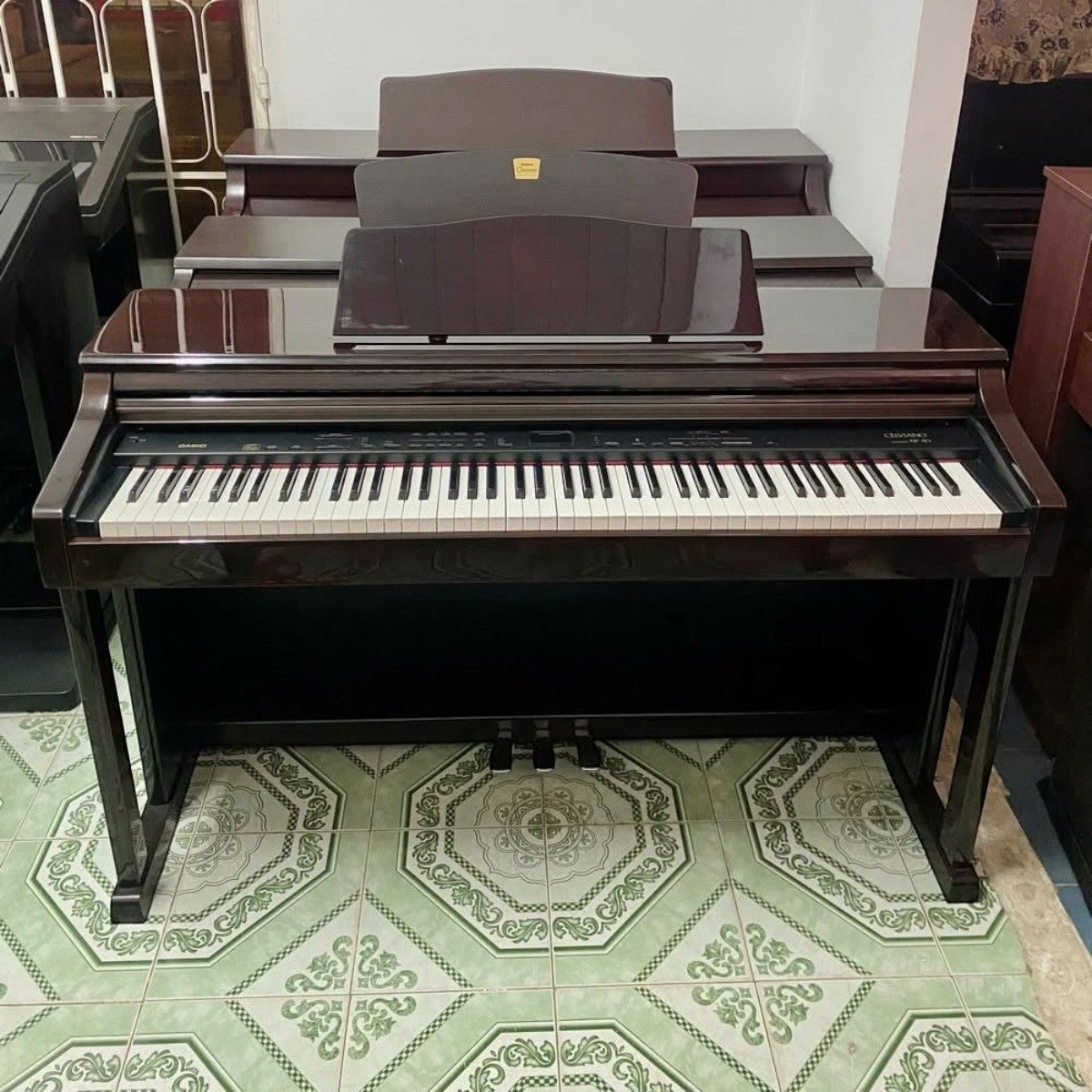 Đàn piano điện Casio AP40 dáng tủ màu nâu gỗ sang trọng tại Tân Nhạc Cụ, thiết kế 88 phím búa đàn và 3 pedal cố định.