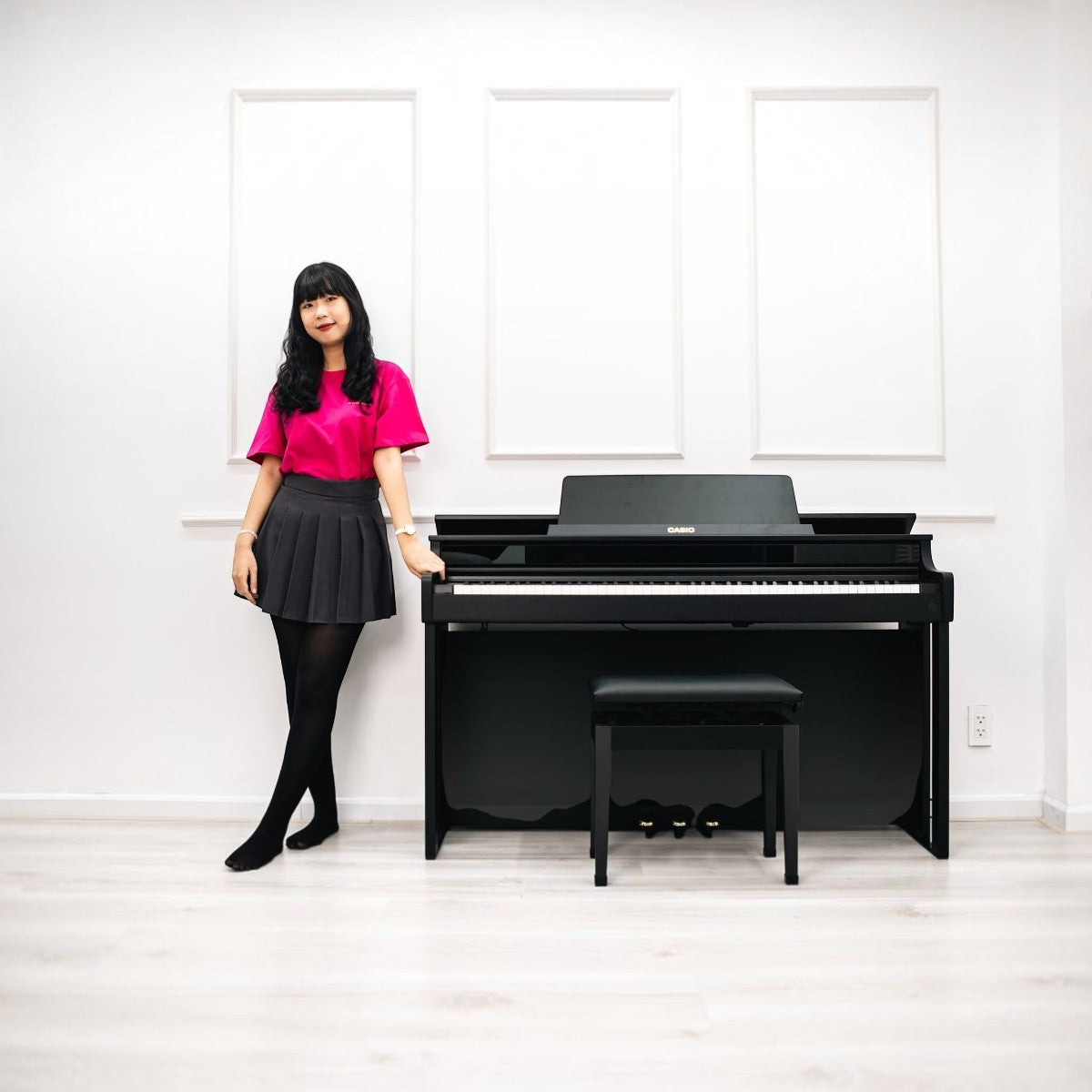 Cô gái đứng cạnh đàn piano điện Casio AP-550 màu đen sang trọng tại showroom TÂN NHẠC CỤ