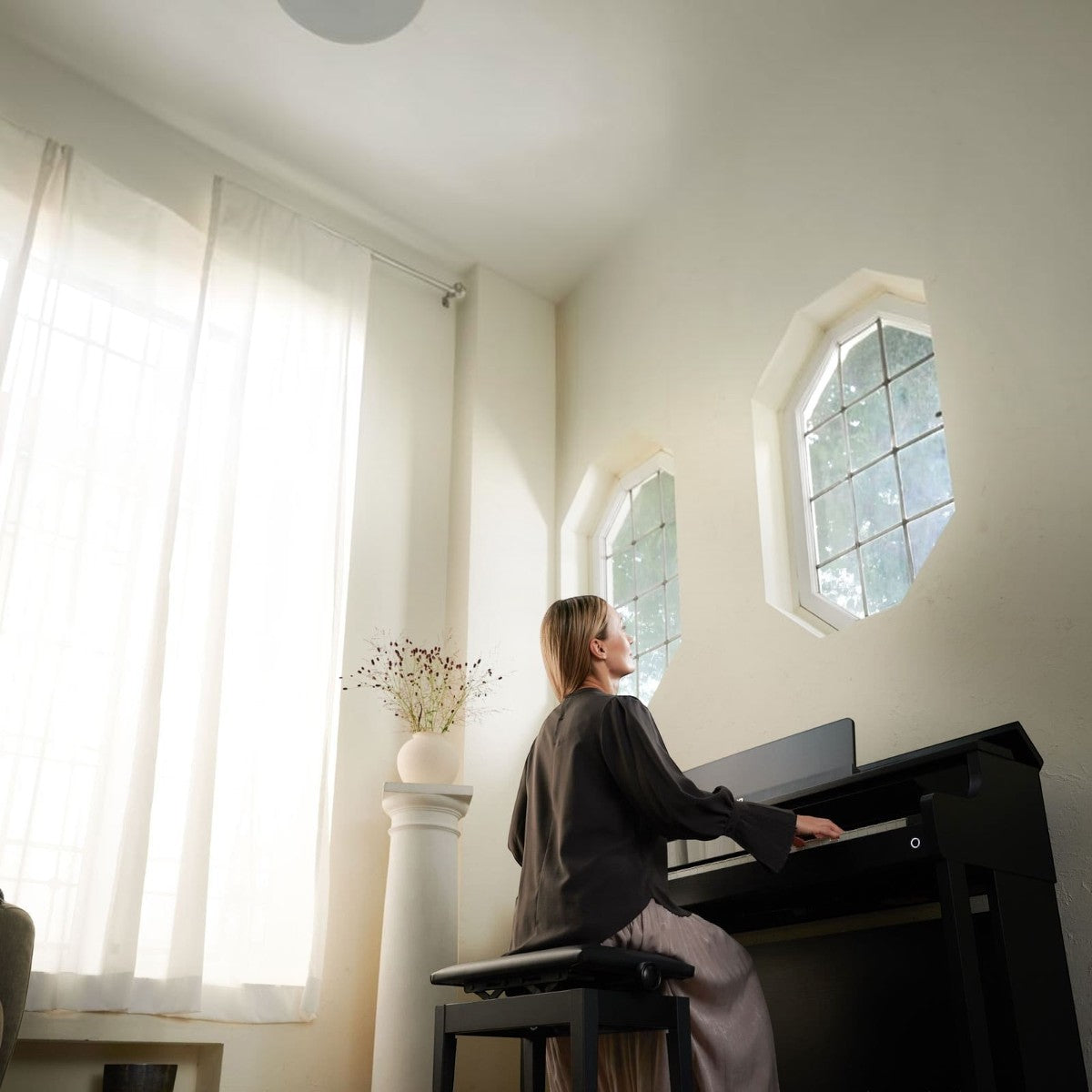 Người phụ nữ chơi đàn piano điện Casio AP-750 màu đen sang trọng trong không gian phòng khách sáng sủa tại TÂN NHẠC CỤ